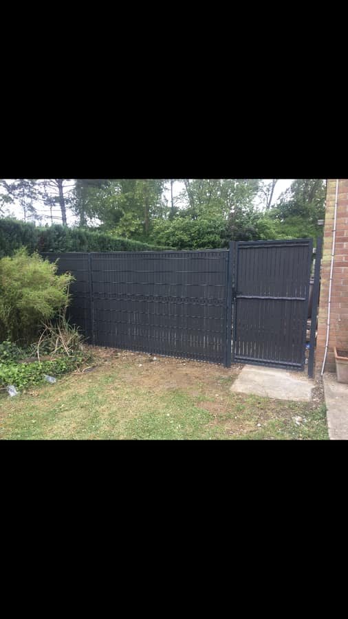 Cloture rigide anthracite avec portillon installee en fond de jardin